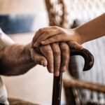 child-s-hand-over-old-man-s-hand-holding-a-cane (2)