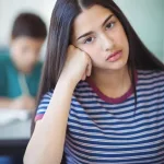 portrait-of-sad-schoolgirl-sitting-in-classroom-YY6NWM3-1