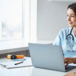 Charming female doctor using laptop in clinic