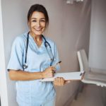 joyful-female-doctor-with-clipboard-standing-in-cl-2021-09-04-14-34-18-utc (1)